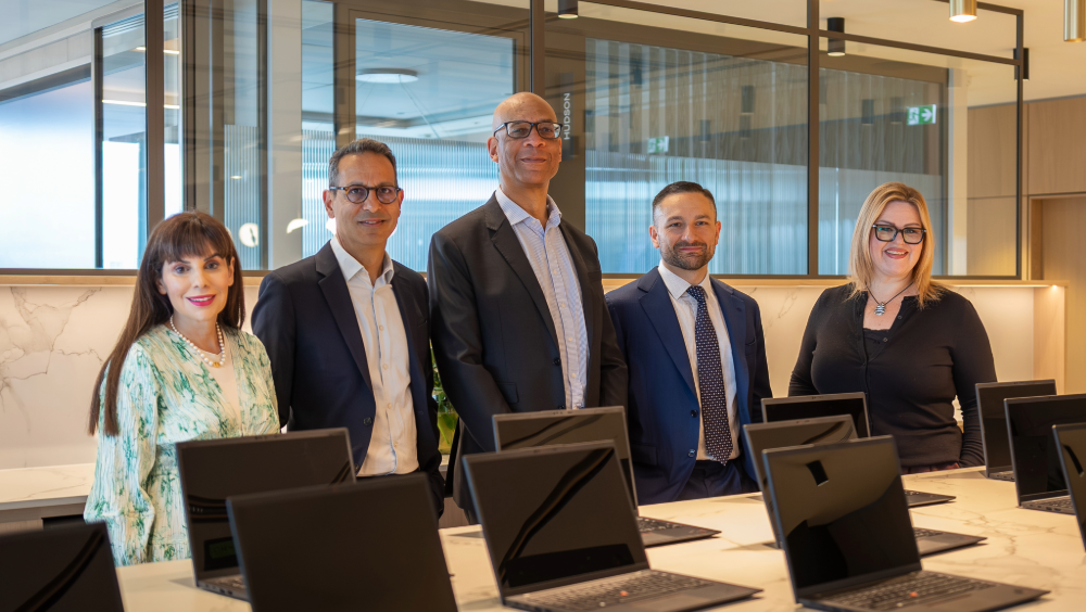 OMERS and Oxford London Office Five people standing in front of a table of open laptops