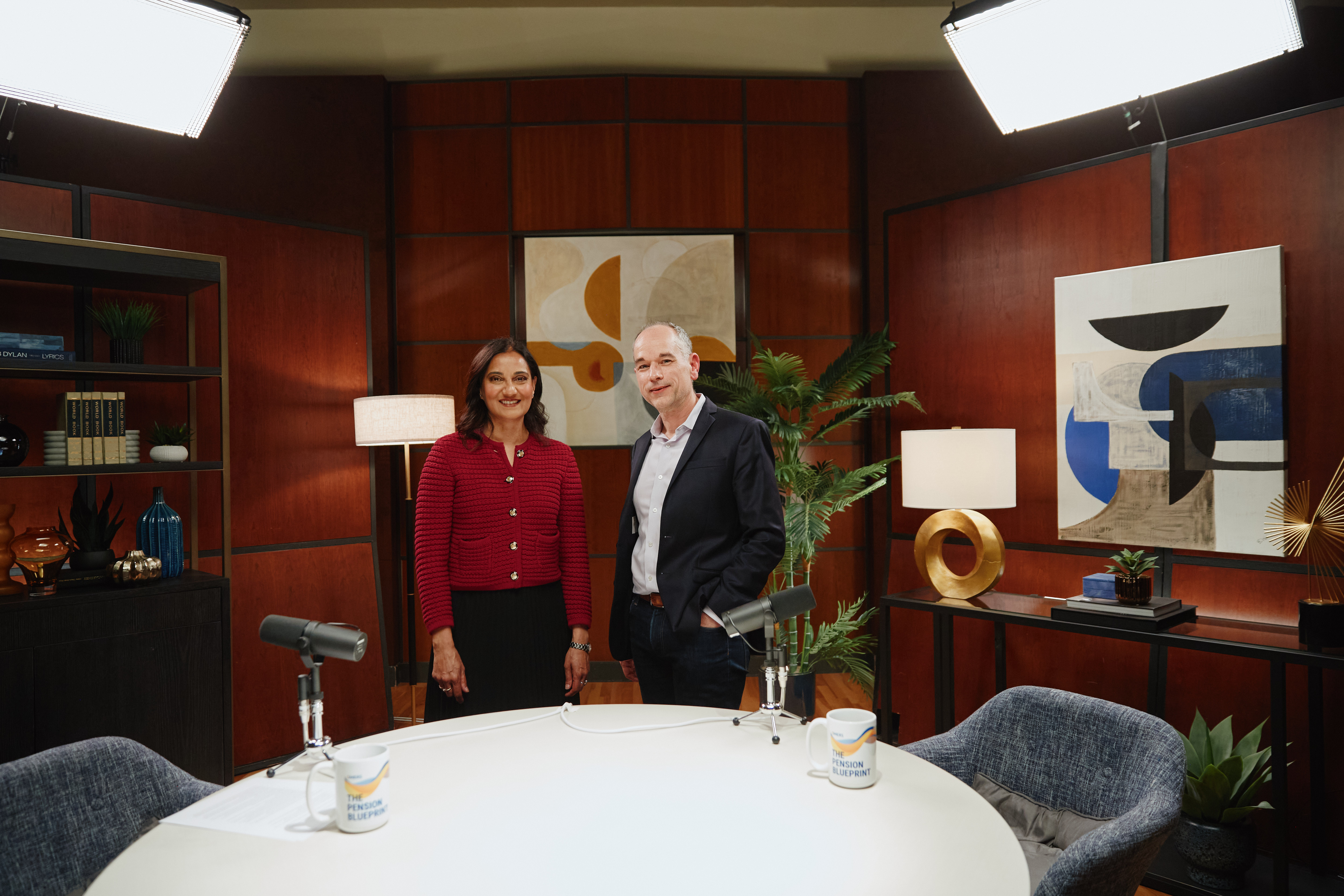 Two people standing behind a table with microphones