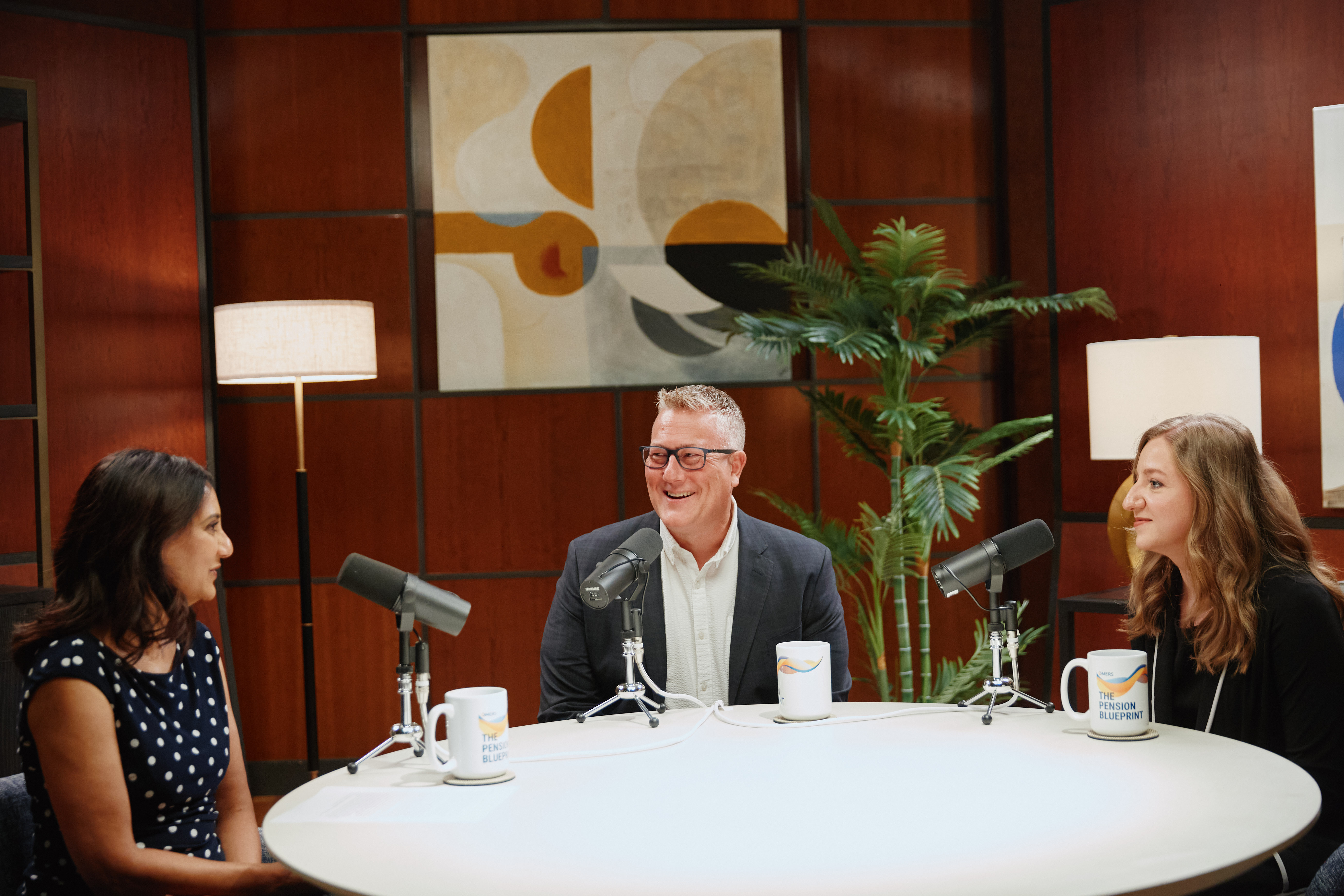 Three people sitting at a table with microphones