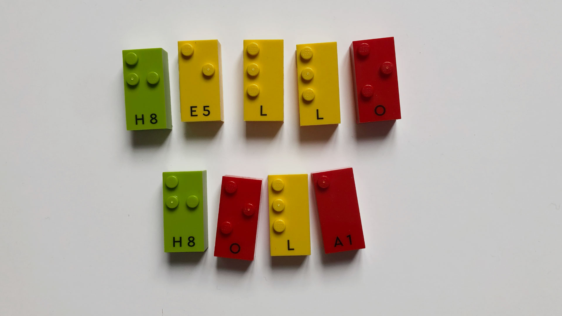 Words 'Hello' and 'Hola' written with LEGO Braille Bricks
