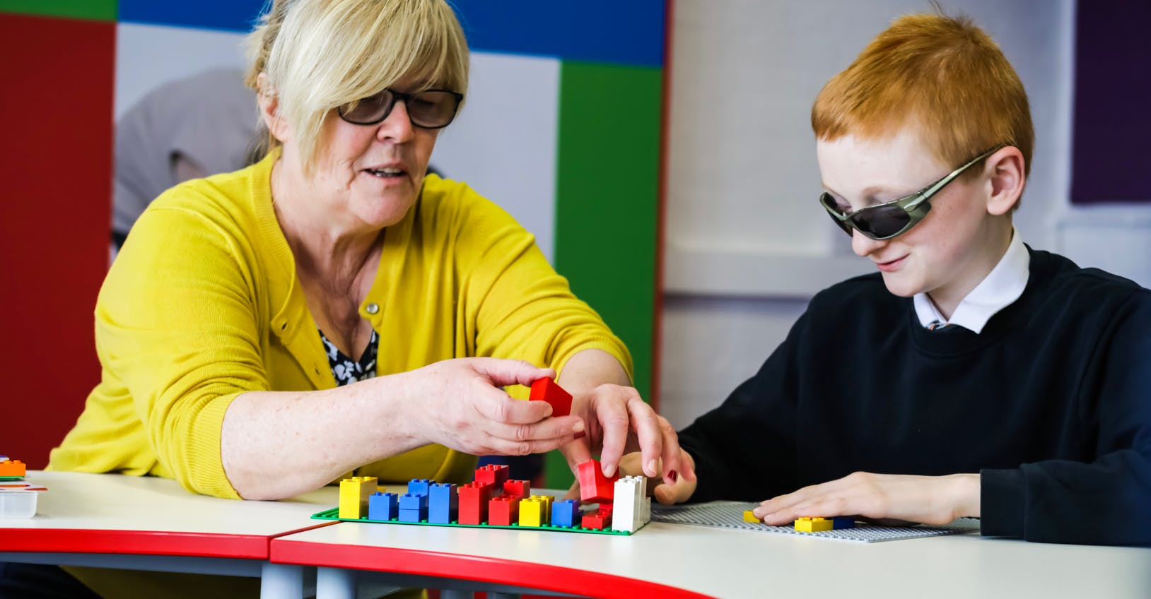 Teacher and child using LEGO Braille Bricks