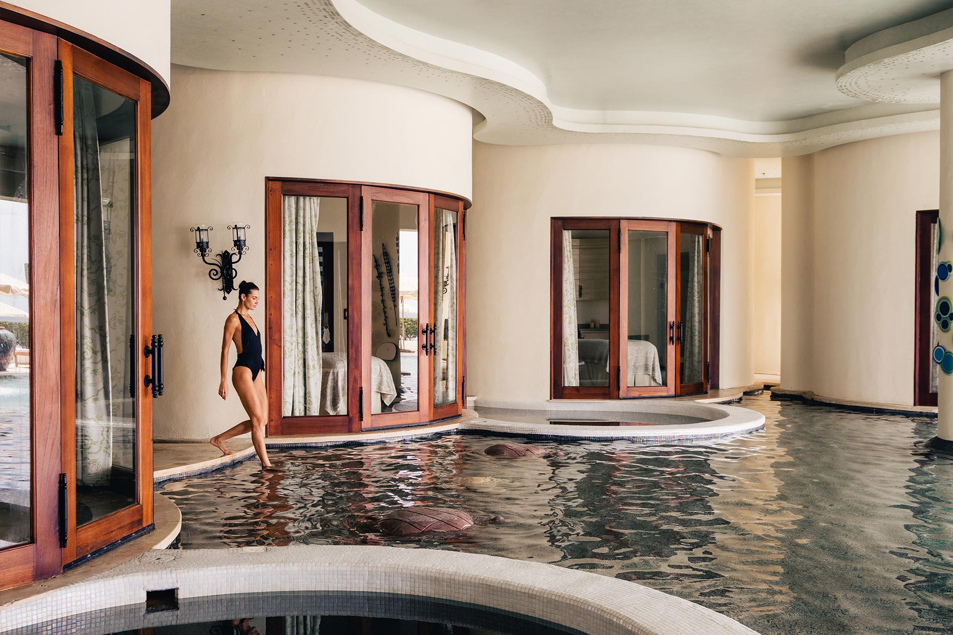 Luxury indoor wellness pool at Waldorf Astoria Los Cabos Pedregal, featuring elegant curved architecture, direct suite access, and a serene spa-inspired environment.