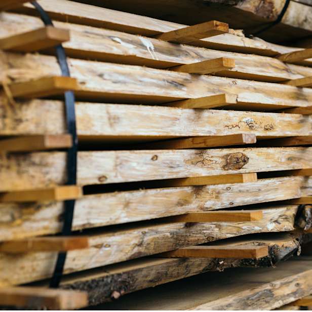 Stack of wooden planks with metal band and horizontal struts