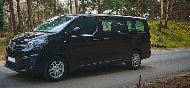 Black large car driving through a woodland