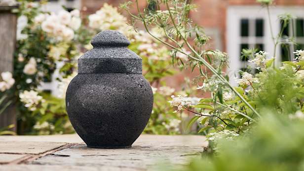 Black urn outside in a garden.