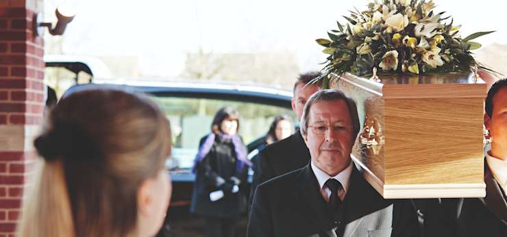 Pallbearers carrying a coffin into a funeral service.