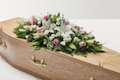 Pink and white rose and lily floral display on top of coffin