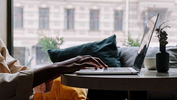 Someone using a laptop on a table.