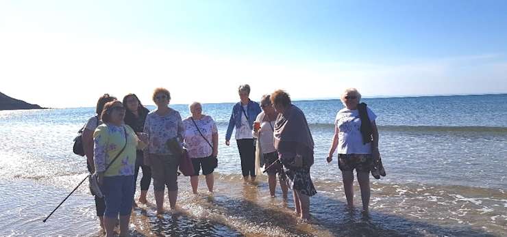Bereavement group having a paddle in the sea on a summers day.