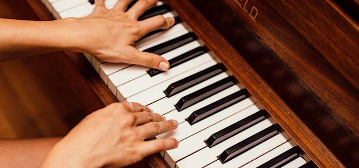 Hands playing a piano