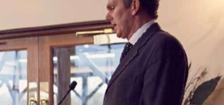 Man speaking at lectern at a funeral
