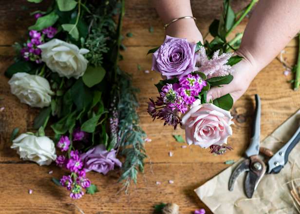 Purple flowers being arranged on a table