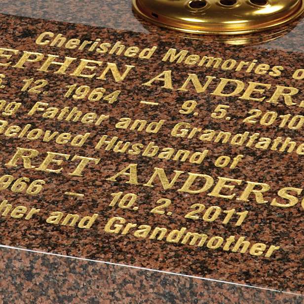 Close up of gold inscription on brown stone