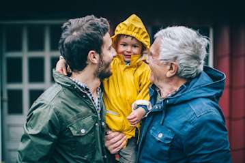 Dad, son and grandchild out in their rain coats.