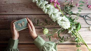 A wooden table with flowers and butterfly gift