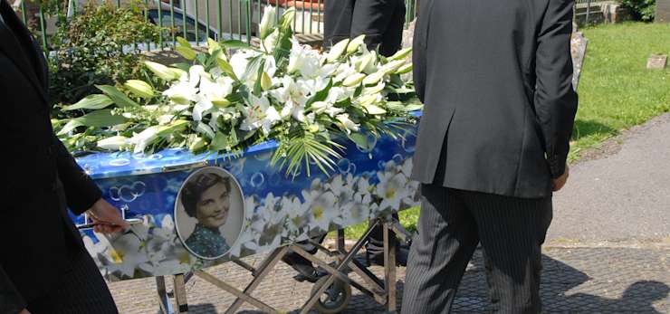 Image of bubble print coffin being wheeled on a funeral