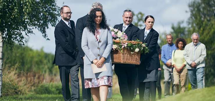 Funeral procession through a field