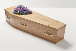 Zoomed out shot of purple flowers on top of coffin