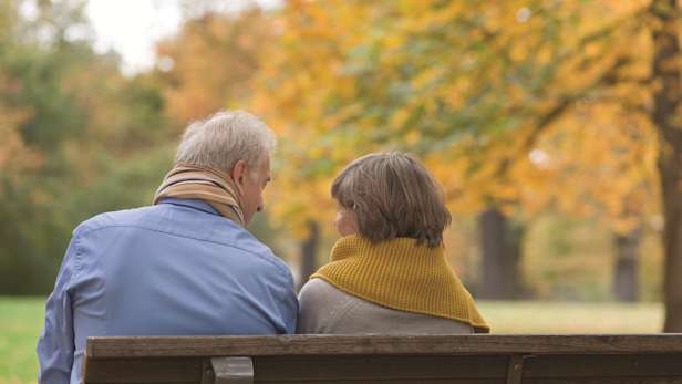 A couple having a conversation on a bench