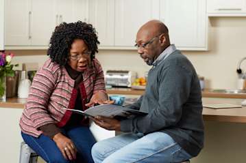 Couple sat in their kitchen discussing funeral plans.