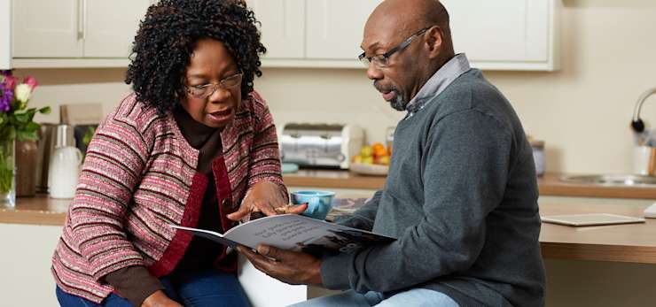 Couple sat in their kitchen discussing funeral plans.