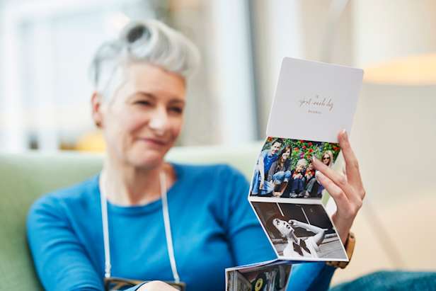 Woman smiling looking at keepsake photographs