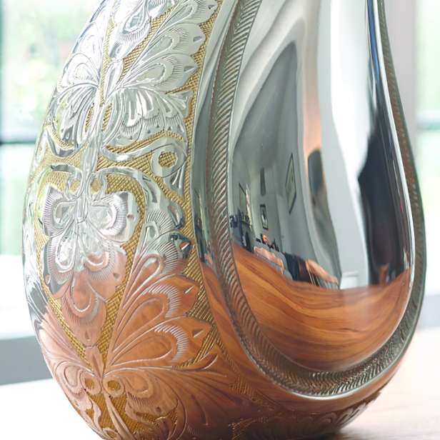 Close up image of the decoration on a silver teardrop urn