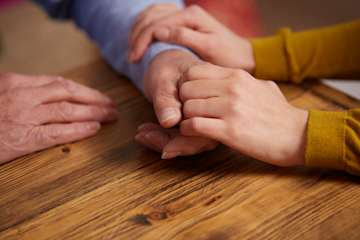 Couple holding hands consoling each other.