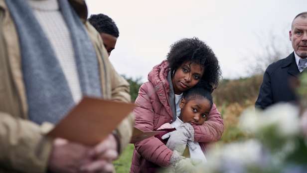 Family attending a funeral service outside
