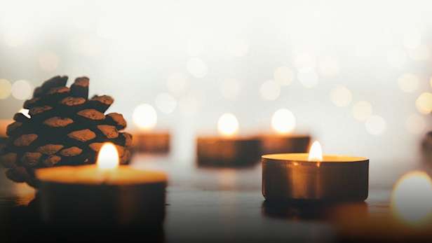 tea light candles and pine cones in soft light.