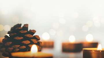tea light candles and pine cones in soft light.