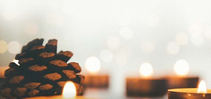 tea light candles and pine cones in soft light.