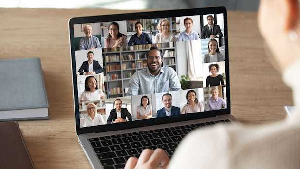 Woman on an online video call with multiple people on her laptop screen