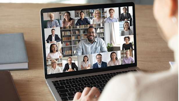 Woman on an online video call with multiple people on her laptop screen