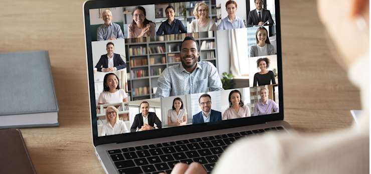 Woman on an online video call with multiple people on her laptop screen
