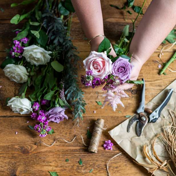 Hands putting together a bouquet of roses