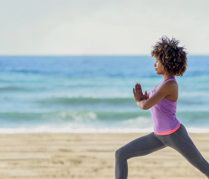 Mulher se exercitando na praia