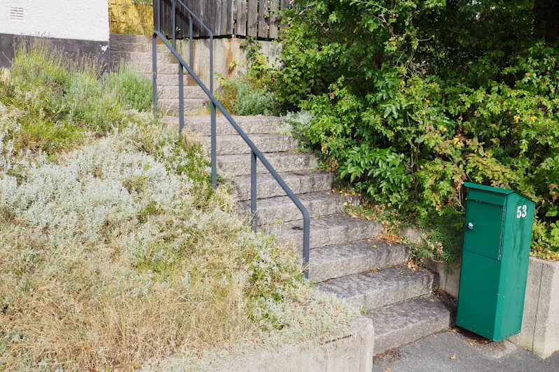 Stentrappa med smidesräcke.