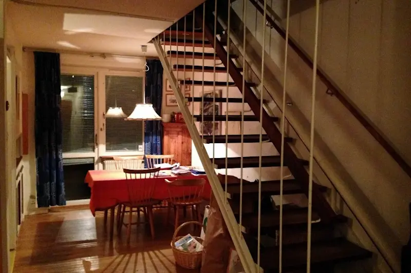 Exempel på trappa i tvåvåningshusen. Trappräcke av vitmålat smide och ledstång av teak.