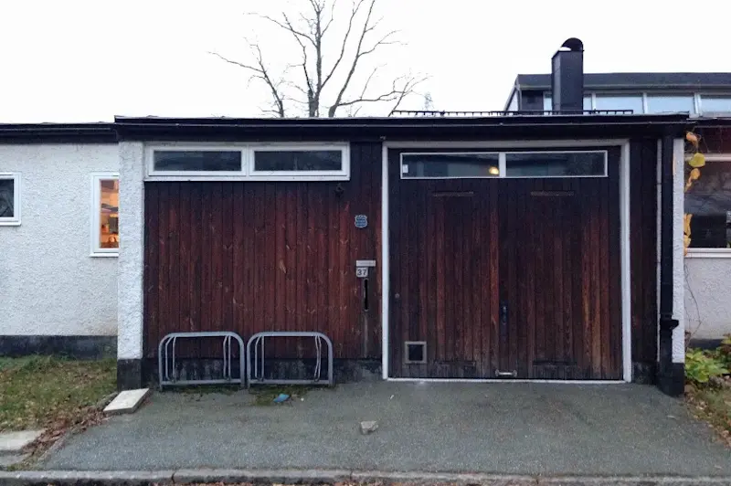 Garageport av tjärad träpanel.