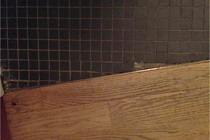 Klinkermosaik i hall och badrum, stavparkett i vardagsrum.