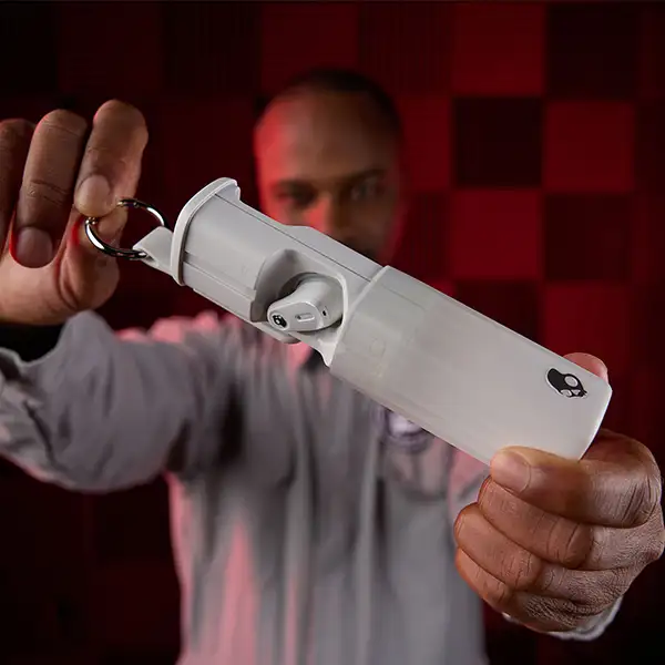 Man som holder ørepropper i etui opp frem mot kamera