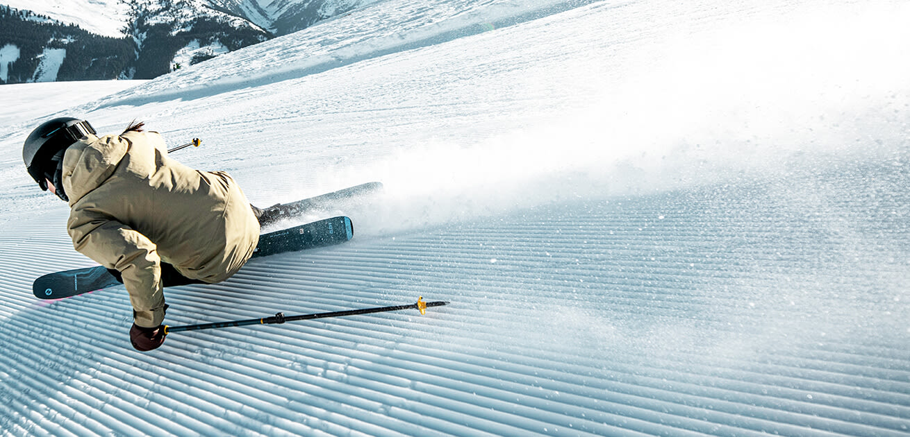 Skier carving a turn on a freshly groomed slope