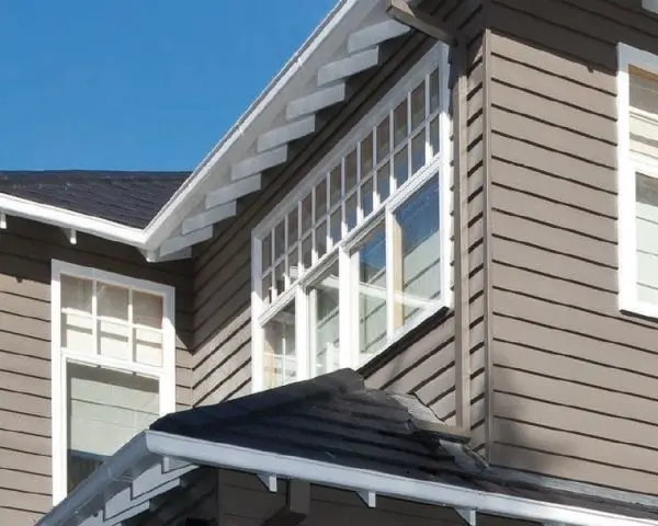 Second story house exterior with grey weatherboards, white eaves and a dark roof