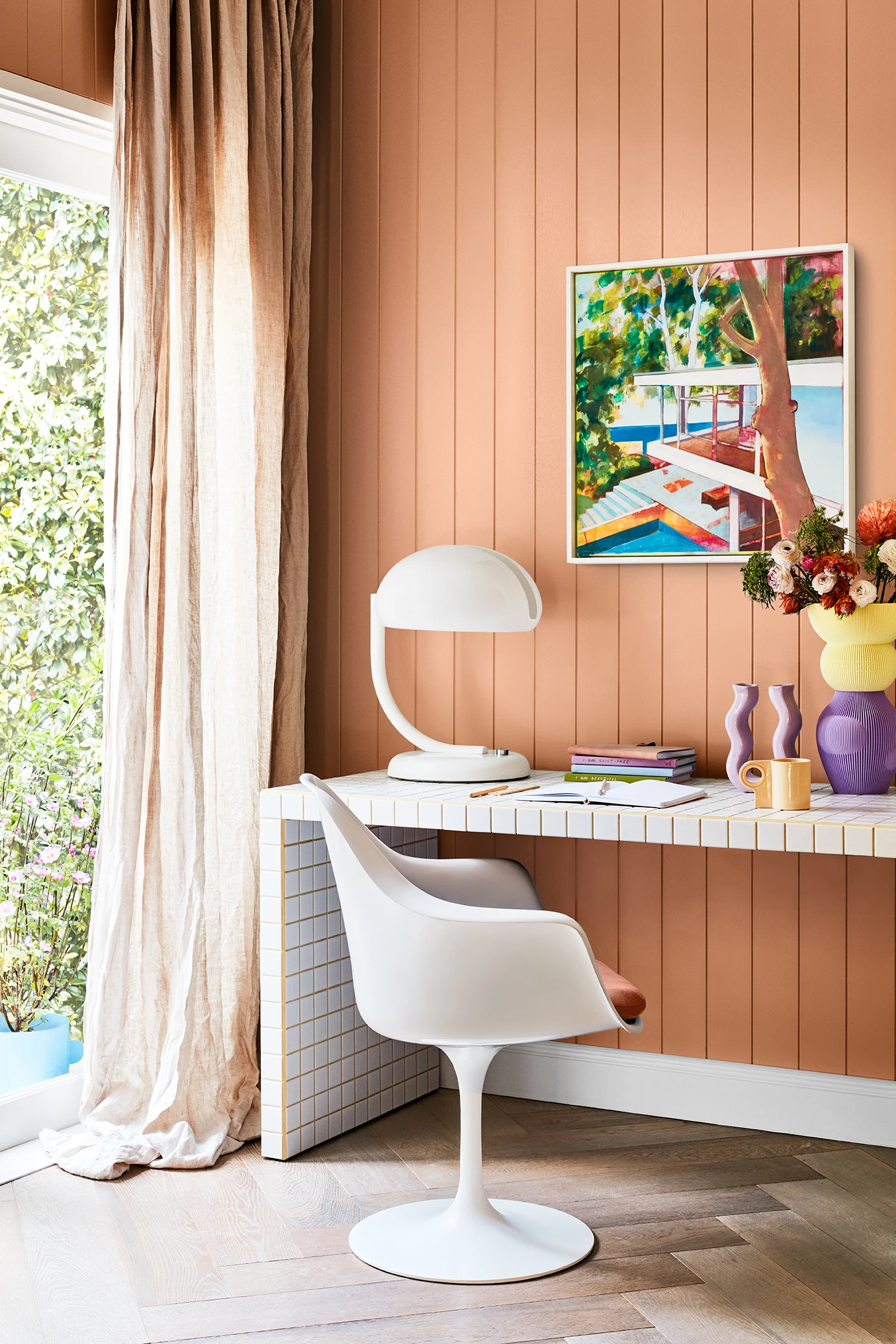 Study wall with VJ paneling painted orange, white desk and chair.