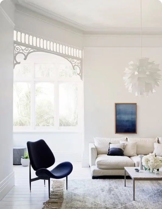 White living room with blue armchair and white couch
