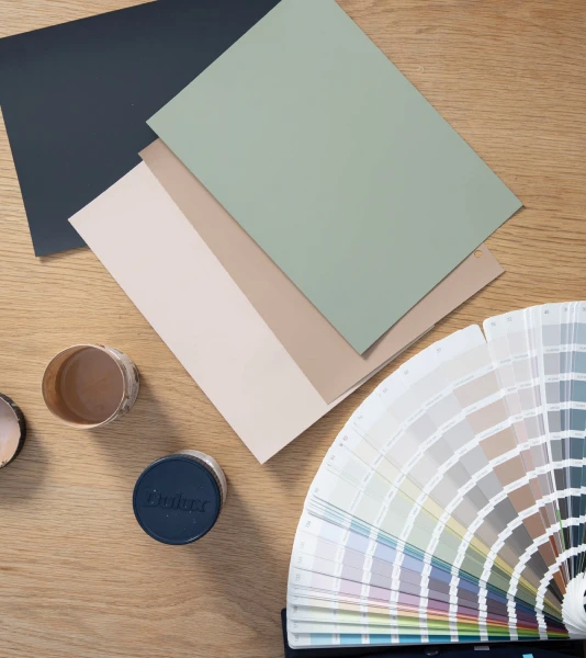 Dulux Colour Sample pot, swatches and fan deck on a table 