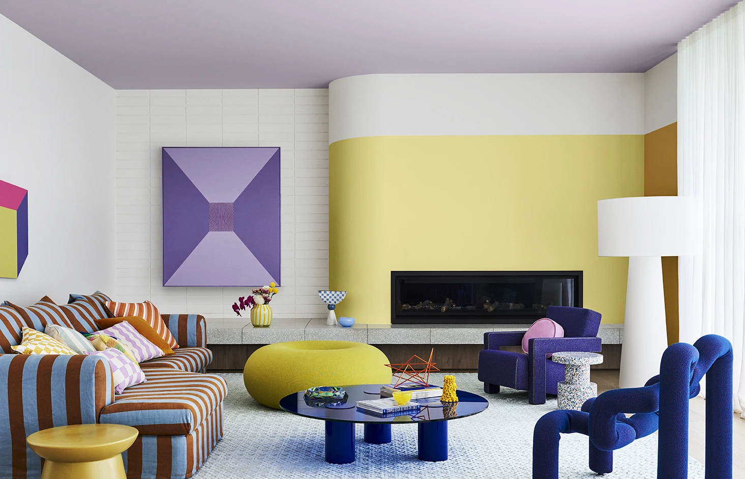 White and yellow living room with purple ceiling and brightly coloured furniture