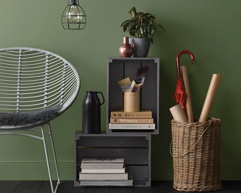 view of black chair and shelving in front of green wall 