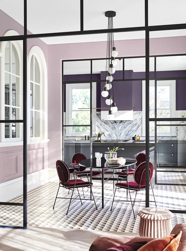 interior pink and purple dining area with red chairs. 